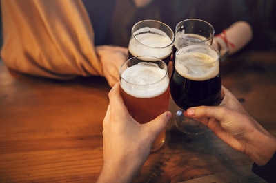 Group of people cheering with beers.