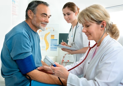 Medical doctor taking a patient's blood pressure.