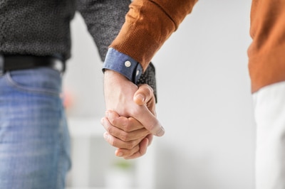 Two men holding hands.