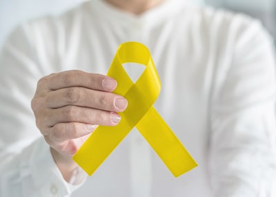 Person holding a yellow ribbon.