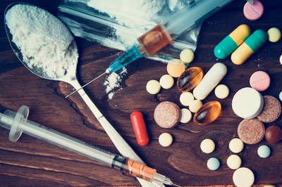 Syringes and pills on a table top.