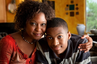 Mother and son hugging each other and smiling.