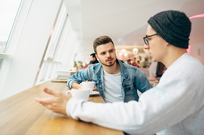 Two young men drinking coffee.