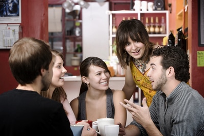 Group of people drinking coffee in a cafe.