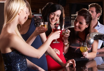 Group of woman out at a club dancing and drinking.