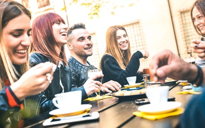 Group of people sitting around a table eating and talking.