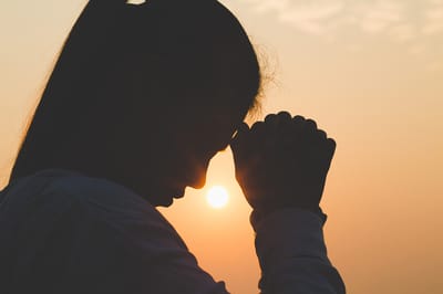 Person placing their hands on their forehead.