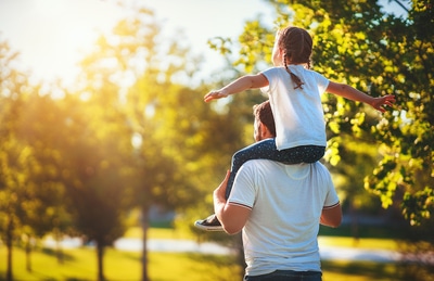 Father holding his daughter on his shoulders.