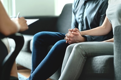 Couple holding hands seeking advice from a rehab specialist.