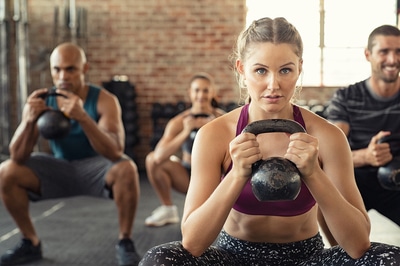 Group of people exercising with kettlebells.