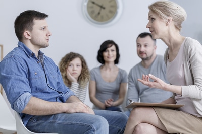 Group of people sitting in a circle having a discussion.