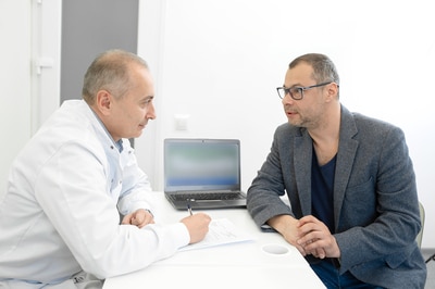Man seeking counsel from a medical physician.