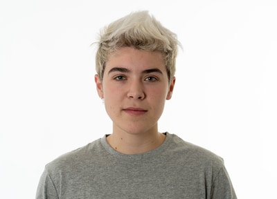Person with short white hair and grey shirt.