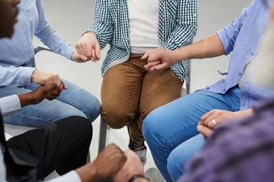 Group of people holding hands in a circle.