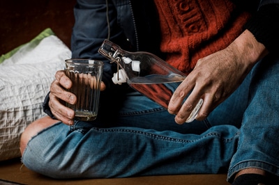 Person pouring alcohol into a glass.