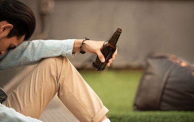 Man sitting alone drinking a beer.