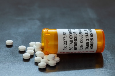 Medication pills pouring out of a bottle.