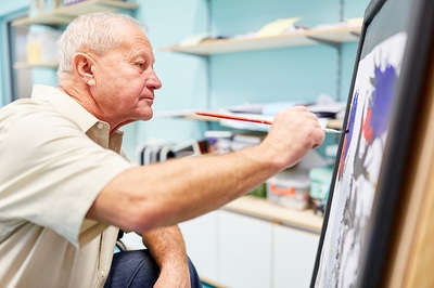 Man painting on a canvas.