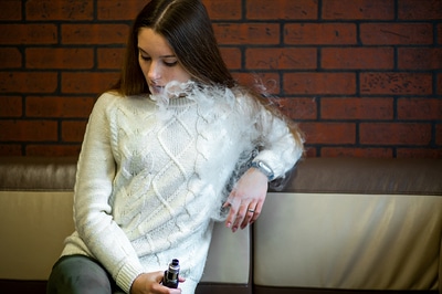 Female teen vaping.