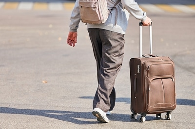 Man pushing his luggage on wheels.