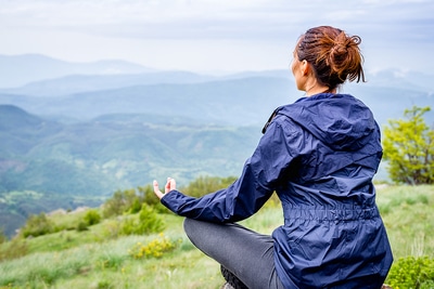 Woman sitting outside in a yoga pose.